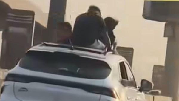 صعود أشخاص على سقف سيارة أعلى...